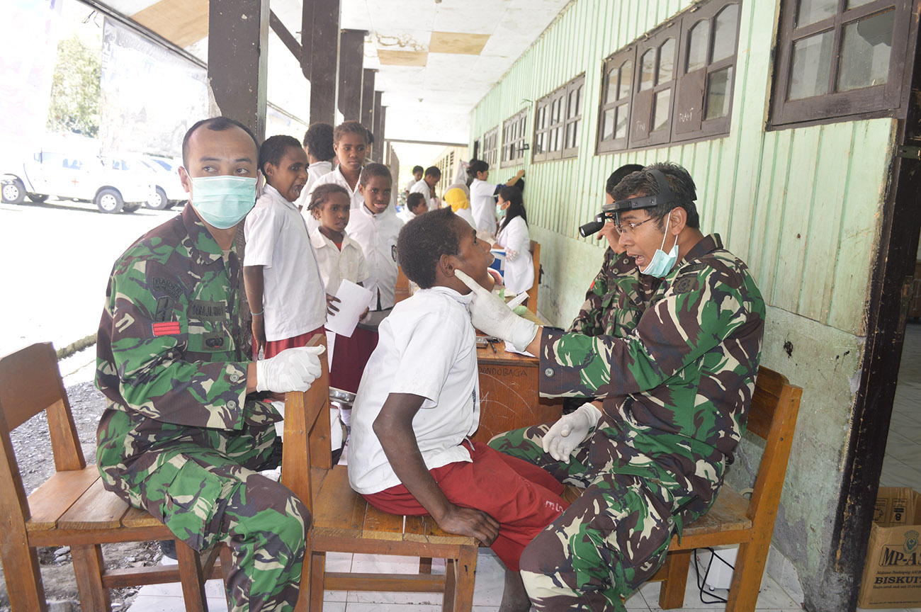 Salah Satu Dokter Dari TNI Tengah Memeriksa Siswa