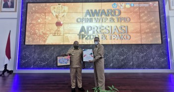Bupati Puncak Jaya Dr. Yuni Wonda, S.Sos, S.IP, MM didampingi Sekretaris Daerah Tumiran, S.Sos, M.AP sesuai menerima piagam penghargaan WTP untuk Ketiga Kalinya